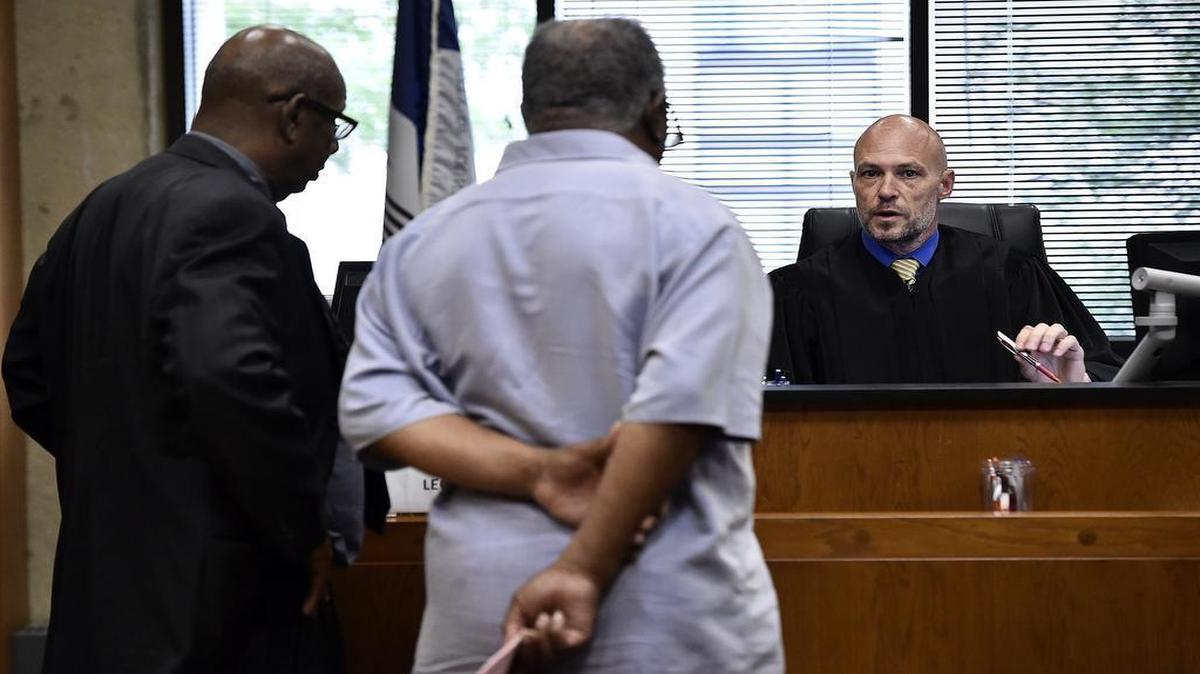 
Judge Todd Wilcher passed sentence Thursday on Elvis “Sonny” Gibson (center) in Housing Court. Gibson’s attorney, Carl Bussey, stood next to his client. 
