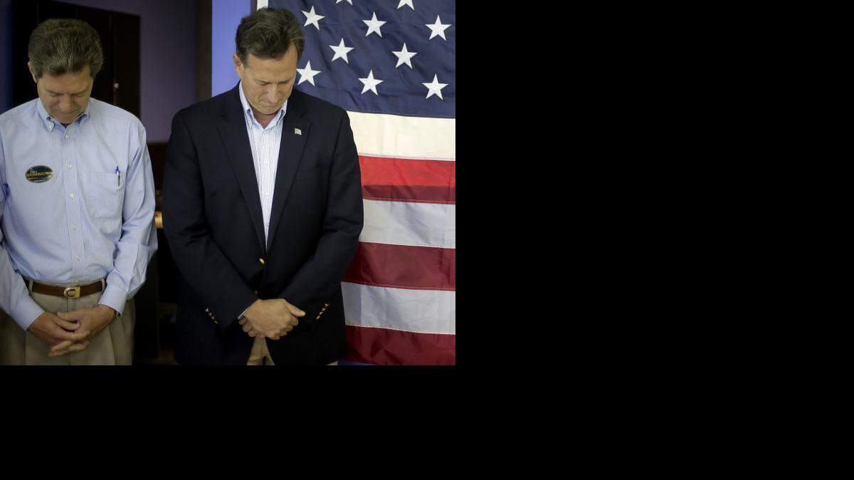 
Former Senator and GOP presidential candidate Rick Santorum (right) and Kansas Gov. Sam Brownback stood for a prayer before a Brownback campaign rally Monday in Olathe.
