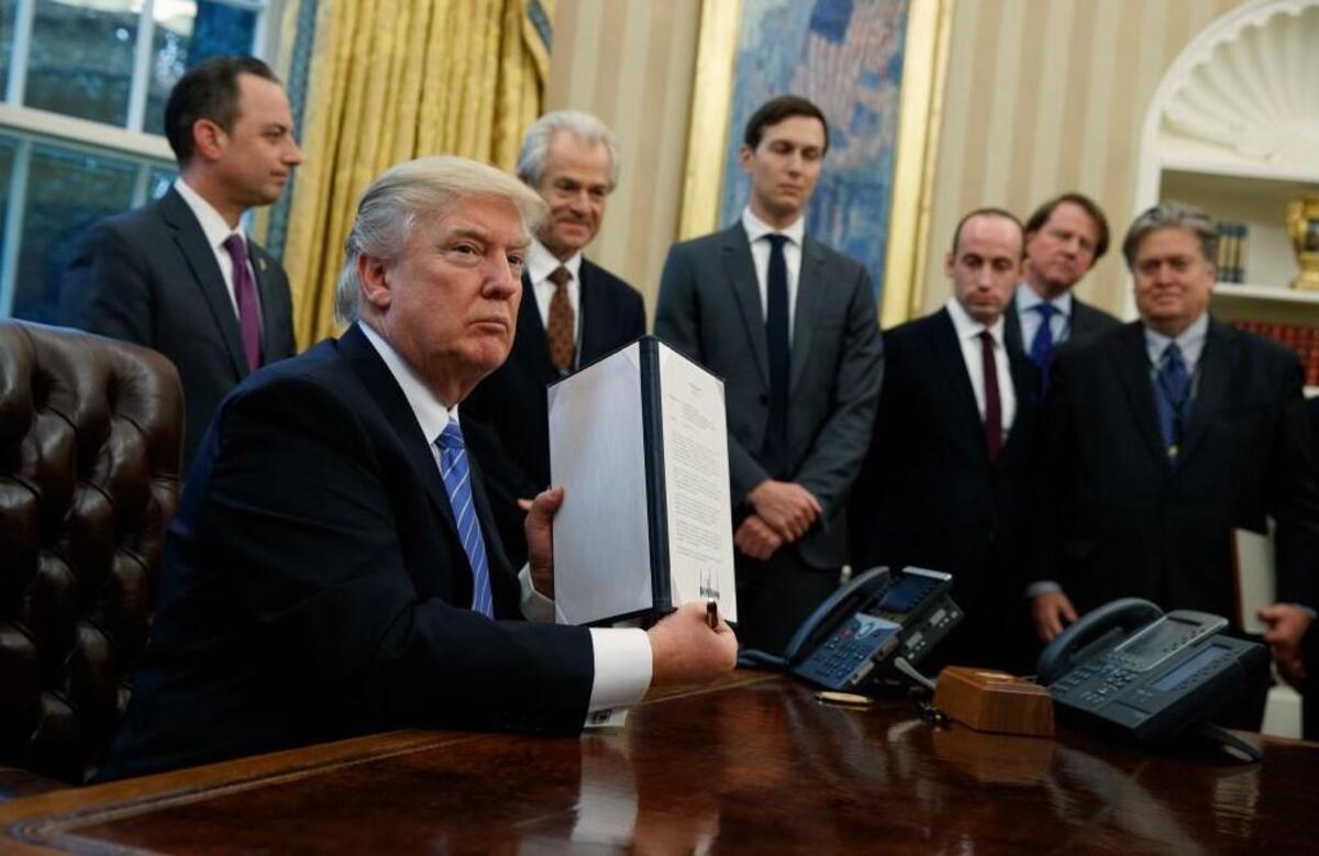 President Donald Trump shows off a signed executive order to reinstitute a policy barring any recipient of U.S. assistance from performing or promoting abortions abroad with money they receive from non-U.S. sources, Monday, Jan. 23, 2017, in the Oval Office of the White House in Washington.