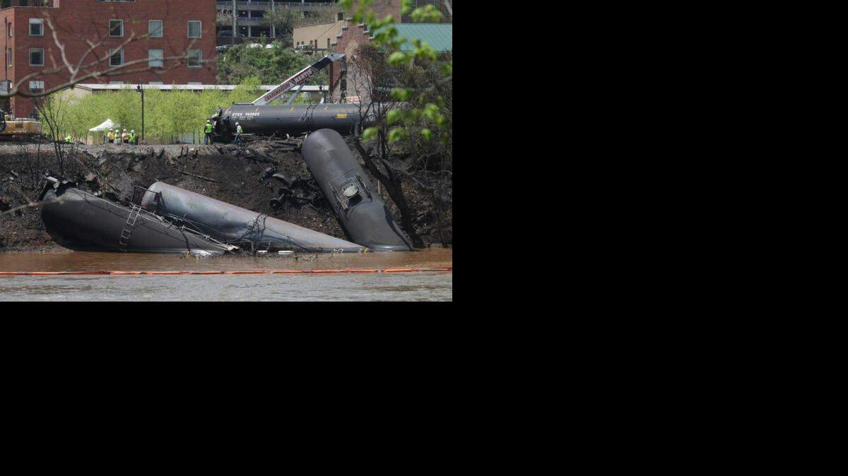 Workers cleaned up derailed tank cars that spilled oil in downtown Lynchburg, Va., in May. The spill into the adjacent James River fouled water supplies for thousands of residents.