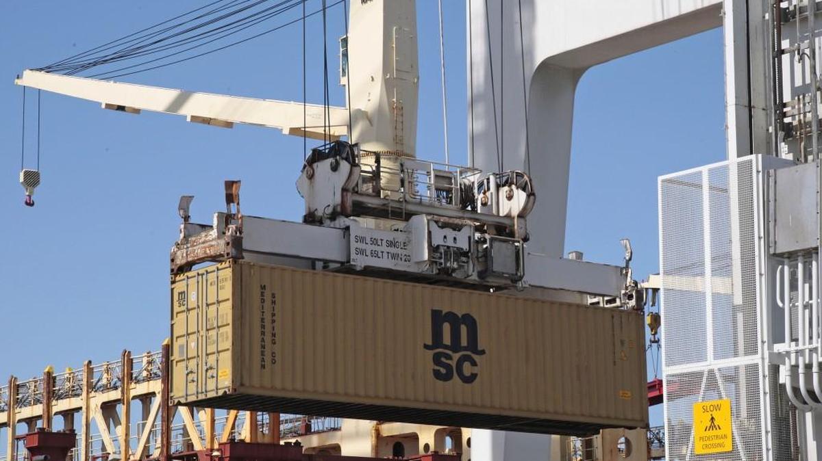 A container is loaded onto a ship docked at the Port of Oakland in California.