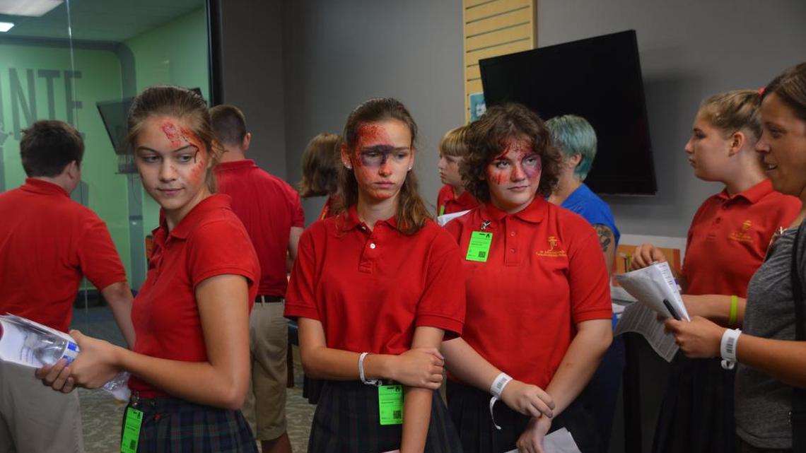 These three mock victims were part of a group of 12 children and two adults who were separated and then reunited at the makeshift shelter at Crowne Point church in Lee’s Summit. From left, Aislinn Plumberg, Sophia Zorich and Natalie Rovello, all 13, said they were confused when separated from their group at a previous shelter station, but Mike Curry, director of Jackson County’s Emergency Preparedness Department, said one of the goals of the drill was to identify and correct potential issues like the one the group experienced.