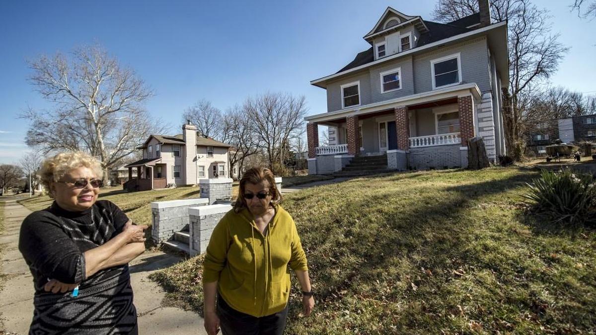 Jessica Brown (left) and Jan Johnson walked past a house Johnson is renovating for her eventual home on Victor Street in Kansas City. Brown also has a rehab projecting. Without the financing to support the work, they push it along more slowly, but they keep at it.