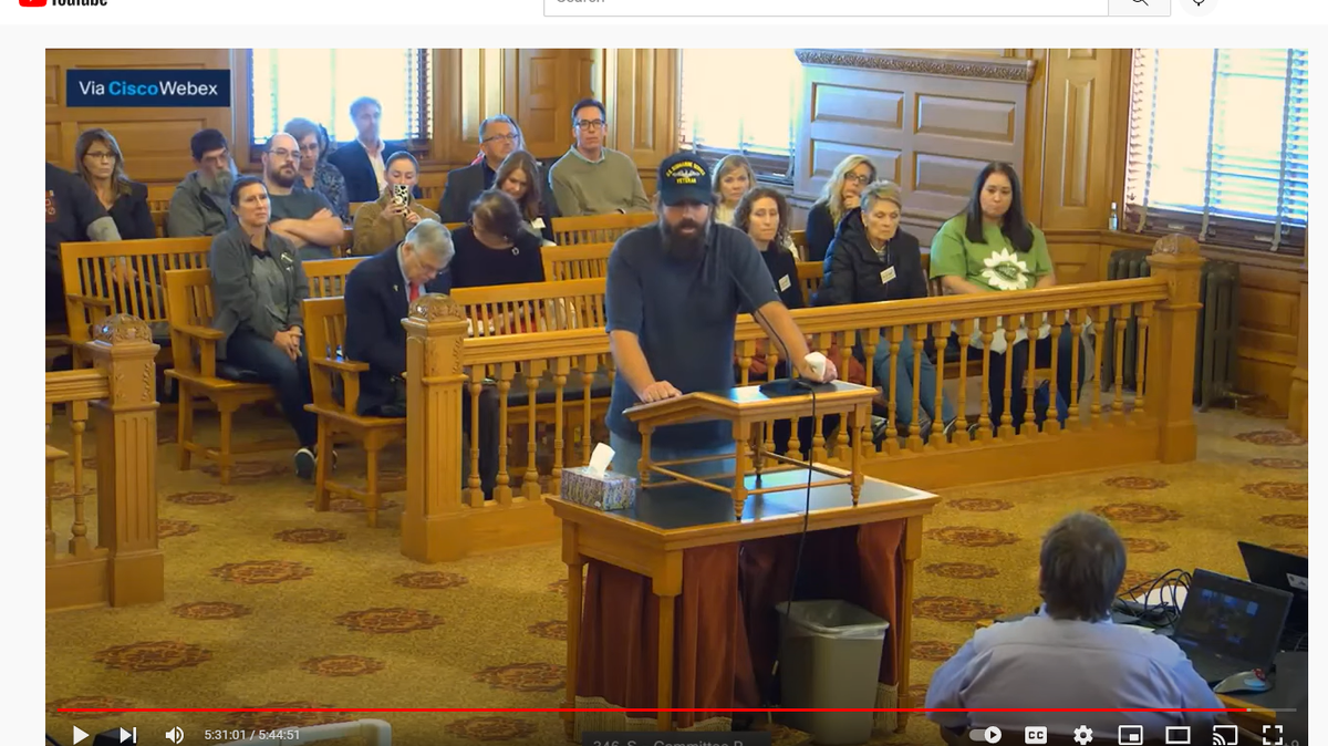 Justin Spiehs speaks to a Kansas legislative committee, moments before he begins a profanity-laced tirade against a journalist. Audio of his comments has been removed from official video of the event.