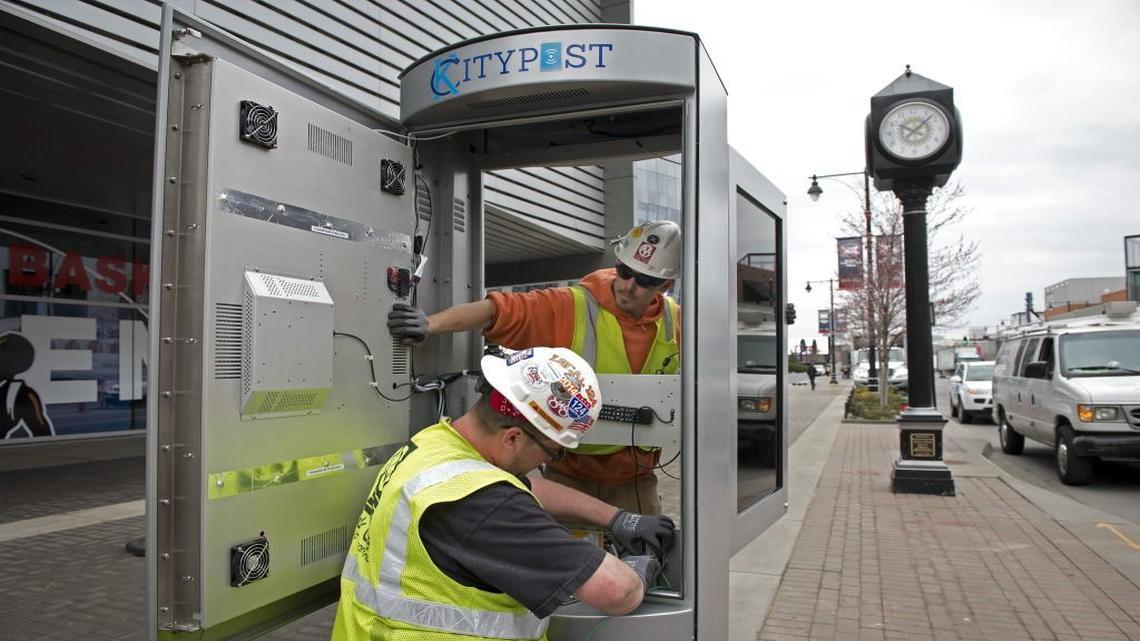 Workers Chris Gabhart (lower) and Phillip Hougham from Mark One Electric Company worked on the installation of one of Kansas City's first Smart City kiosks earlier this month just outside the College Basketball Experience. Kansas City has been named a finalist for a $50 million award in the Beyond Traffic Smart City Challenge.