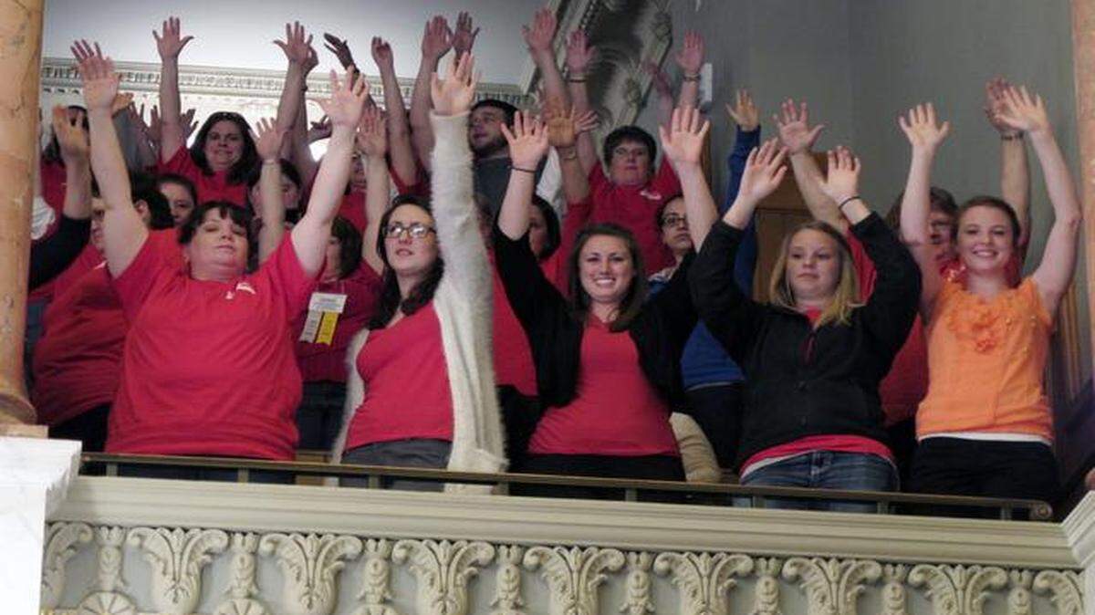 
In April, red-shirted members of the Kansas National Education Association in the gallery of the Kansas House chamber raised their hands to show their support for public schools. At the time, lawmakers approved an education funding bill but eliminated a law that gave teachers the right to hearings if they are fired and had been on the job at least three years. The teachers union is now suing the state to restore that right.
