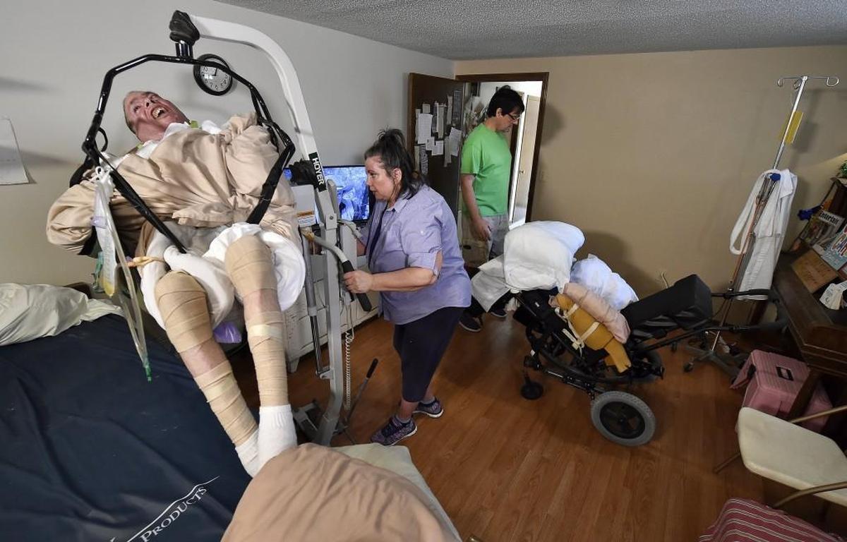 Vicki Distefano and her husband Mark Perbeck spend hours preparing her brother Mike to be moved from his bed to his chair every day. Mike suffered a traumatic brain injury in a motorcycle accident 11 years ago.