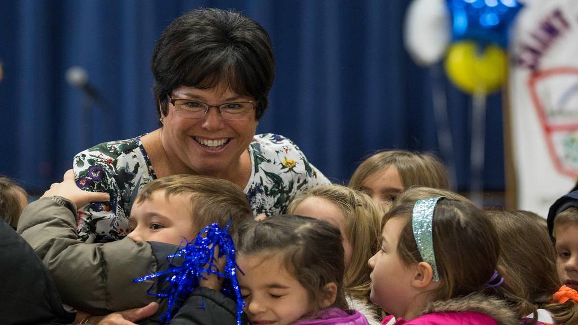 Lisa Fox received a hug from her class during a surprise assembly Wednesday at St. Joseph Catholic School in Shawnee. Fox’s big idea brought her school big money.