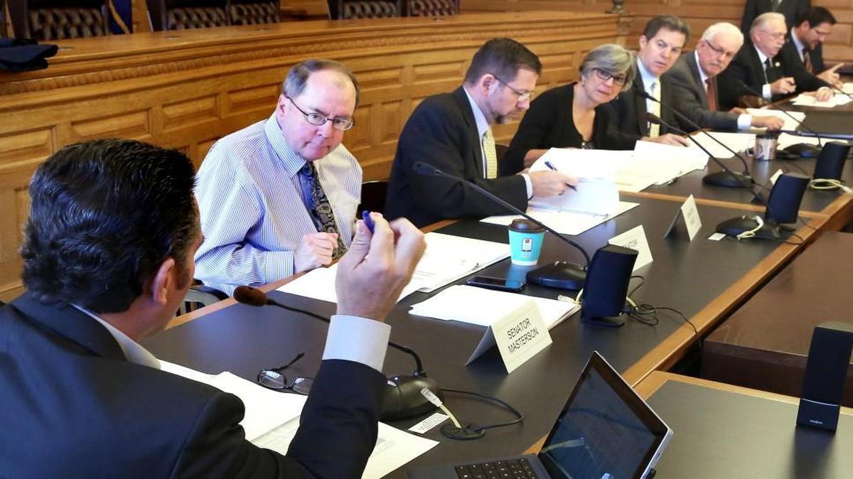 Kansas Gov. Sam Brownback (fifth from left) and legislative leaders on the State Finance Council met Monday in Topeka. The governor and the council approved extra cash for school districts that face falling property values and other pressures.