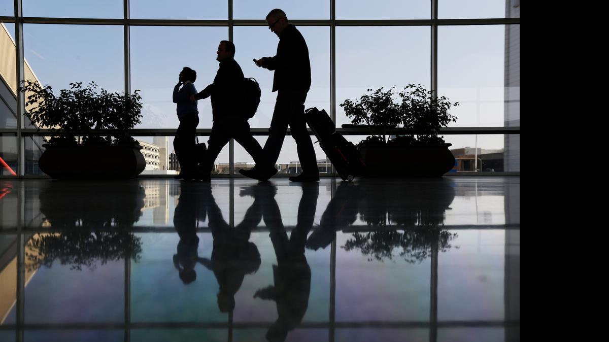
Travelers pass through a corridor at Philadelphia International Airport in Philadelphia. The U.S. government is investigating possible collusion between major airlines to limit available seats.
