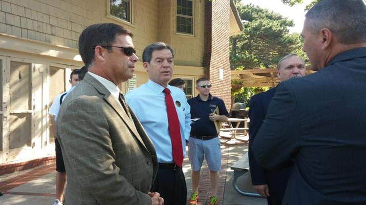 
Kansas Gov. Sam Brownback (in red tie) chatted Monday with Jim Hinson (left), the superintendent of the Shawnee Mission School District, at Antioch Park in Merriam before an event in which the Republican announced his goals for education if he is re-elected.
