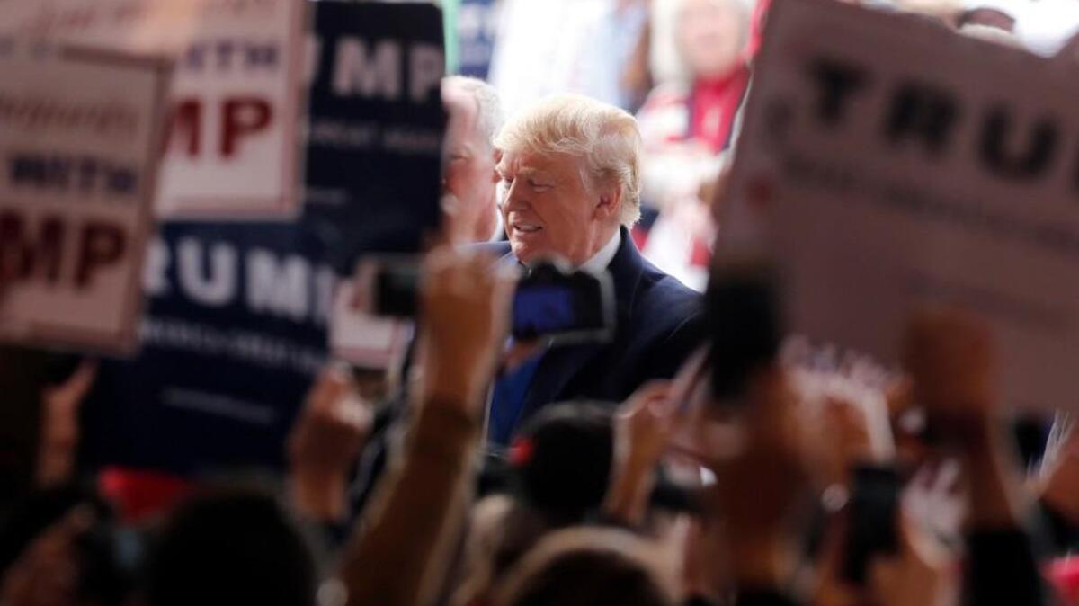 Republican presidential candidate Donald Trump shakes hands as he arrives at the Wright Brothers Aero Hangar for a rally, Saturday in Vandalia, Ohio.