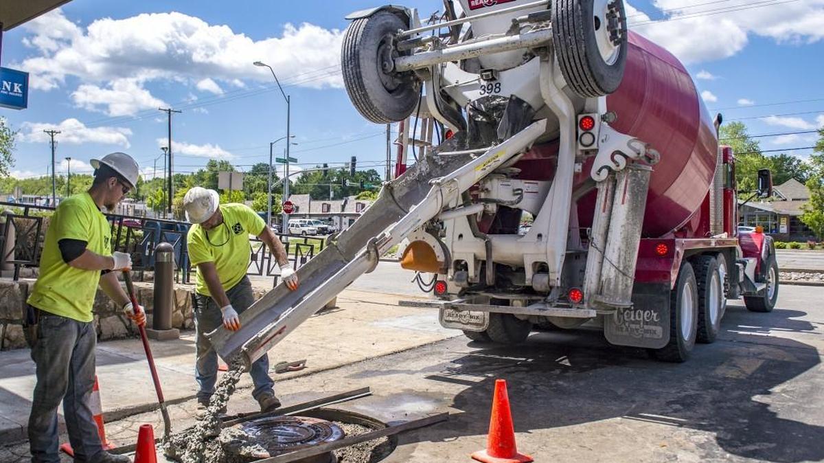 In this 2017 file photo, crews poured concrete over a sewer manhole at the Arvest Bank on Gregory Boulevard. Kansas City residents may get relief from rising water and sewer bills under a new agreement between the city and federal government.