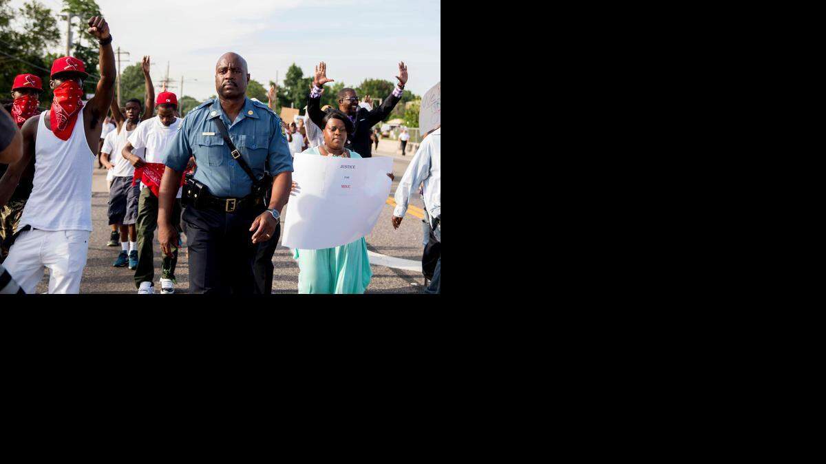Missouri Highway Patrol Capt. Ron Johnson, now in command of officers assigned to keep the peace in Ferguson, Mo., walked alongside demonstrators on Thursday. From 1999 to 2002, Johnson worked out of the patrol’s Troop A in Lee’s Summit.