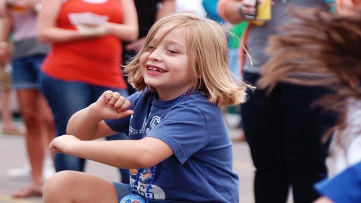 The new owners of Corinth Square tout their involvement in community events. Ellen Lund, 6, of Prairie Village, Kan., danced as Coversmith played in August during the KU Kickoff at Corinth Square in Prairie Village.