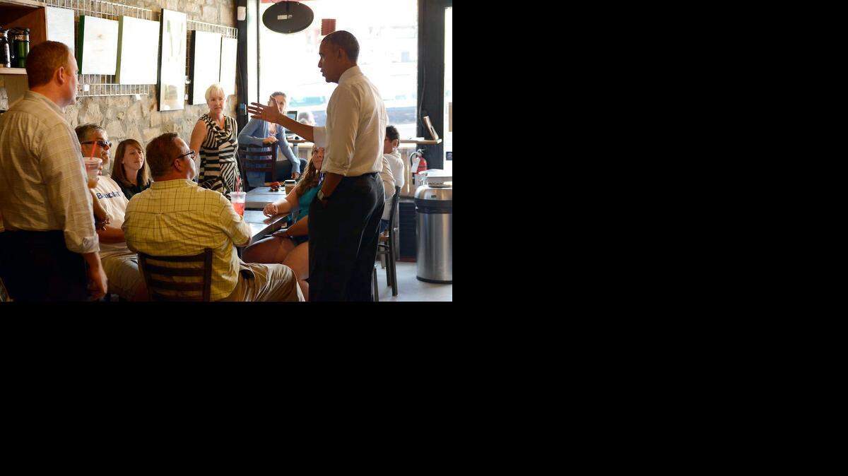 
President Barack Obama chatted with customers and refilled drinks at Parkville Coffee on Wednesday.
