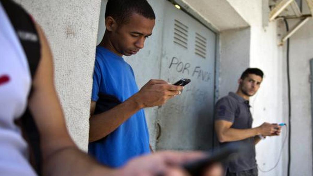 
Students stand outside a building to find an Internet signal for their phones in Havana. In programs revealed by the Associated Press, USAID secretly created a social media program called ZunZuneo, staged a health workshop to recruit activists and infiltrated Cuba’s hip-hop community.
