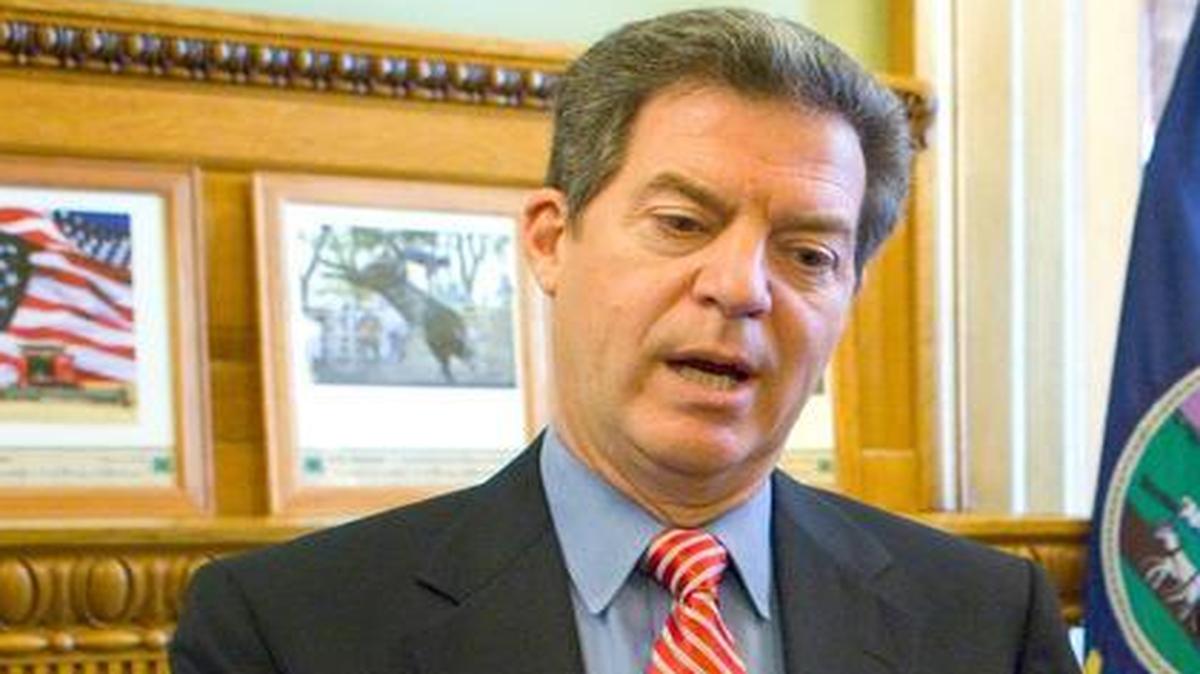 
Kansas Gov. Sam Brownback spoke to reporters Monday after signing a bill in his ceremonial office in the Capitol. Of lawmakers’ efforts to close a projected shortfall of $406 million in the state budget, the Republican said: “These things take a lot of time because you’ve got a lot of people involved, a lot of moving parts.” 
