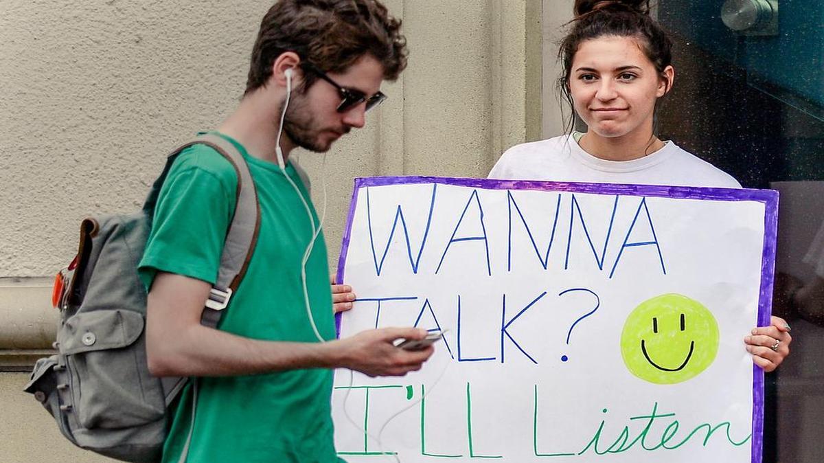 
Students enrolled in Laura Janusik’s communications class at Rockhurst University are learning how to actively listen to other people. Monday night on the Country Club Plaza, they offered welcome ears to anyone who would stop and talk. Ally Rodriguez was one of the students who participated, holding a sign that read, “Wanna talk? I’ll listen.”
