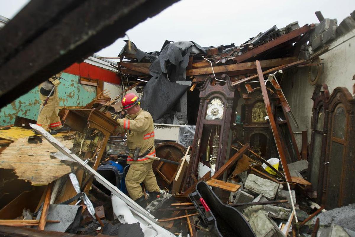 Firefighter Rob Muir of the Kansas City Fire Department (Rescue 31 engine) sorted through the ruins of a clock shop on Main Street in Joplin, Mo., on Monday morning, May 23, 2011, after a tornado swept through the heart of Joplin Sunday evening.