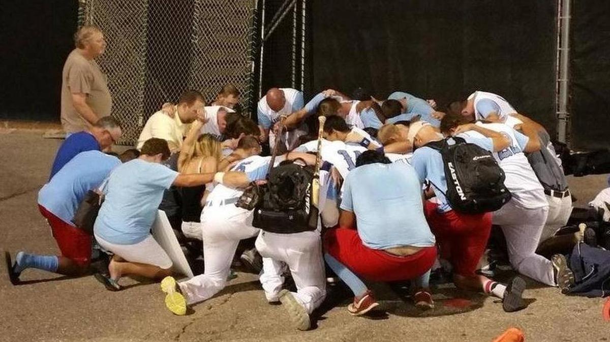 
The Liberal (Kansas) Bee Jays pray Sunday after hearing their batboy, Kaiser Carlile, had died.
