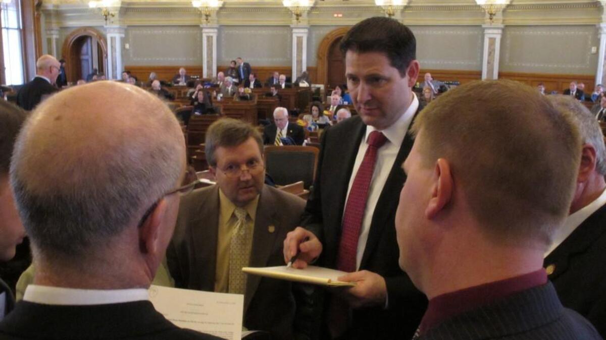 Kansas House Majority Leader Jene Vickrey, center left, R-Louisburg, huddles with Appropriations Committee Chairman Ron Ryckman Jr., center right, R-Olathe, and other lawmakers, staffers and officials to discuss budget legislation, Wednesday at the Statehouse in Topeka.