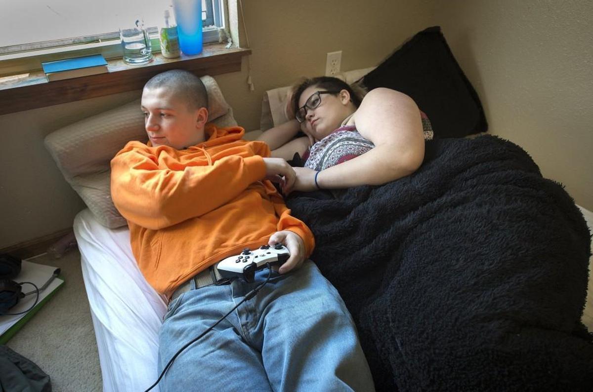 Dylan Knowles, 17, and his 15-year-old wife, Samantha, relaxed in the room they shared in his mom’s Leavenworth home. The couple were married last July.