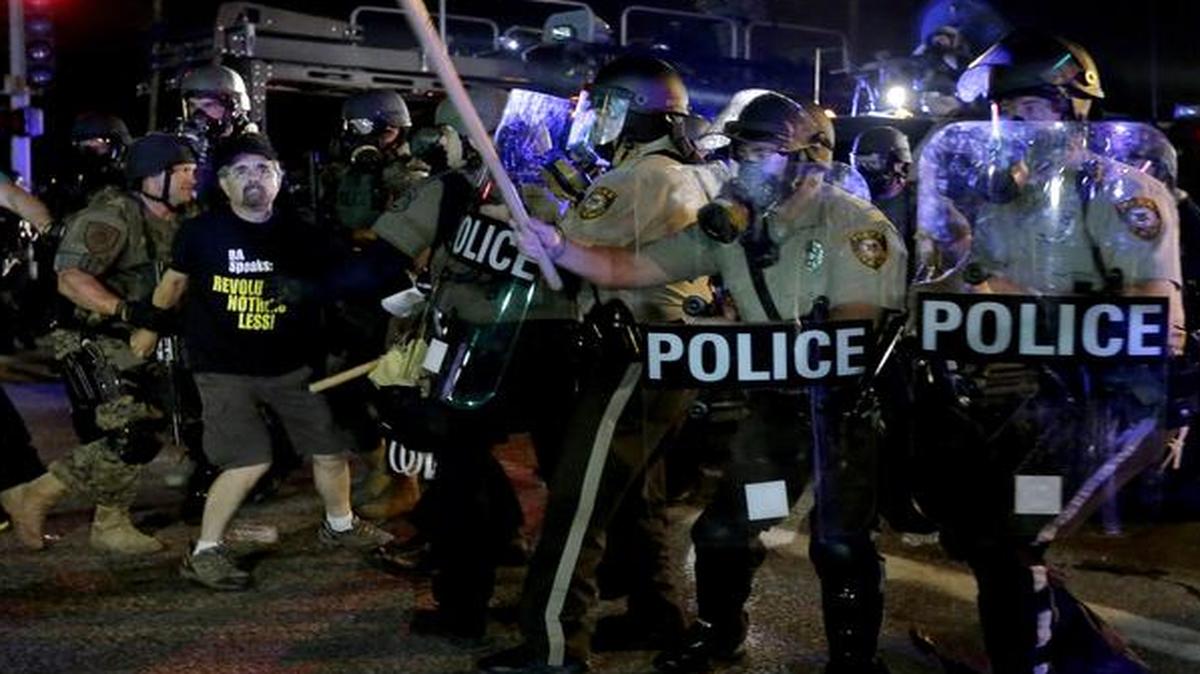 
A man is detained after a standoff between protesters and police Monday, Aug. 18, 2014, during a protest for Michael Brown, who was killed by a police officer Aug. 9 in Ferguson, Mo.

