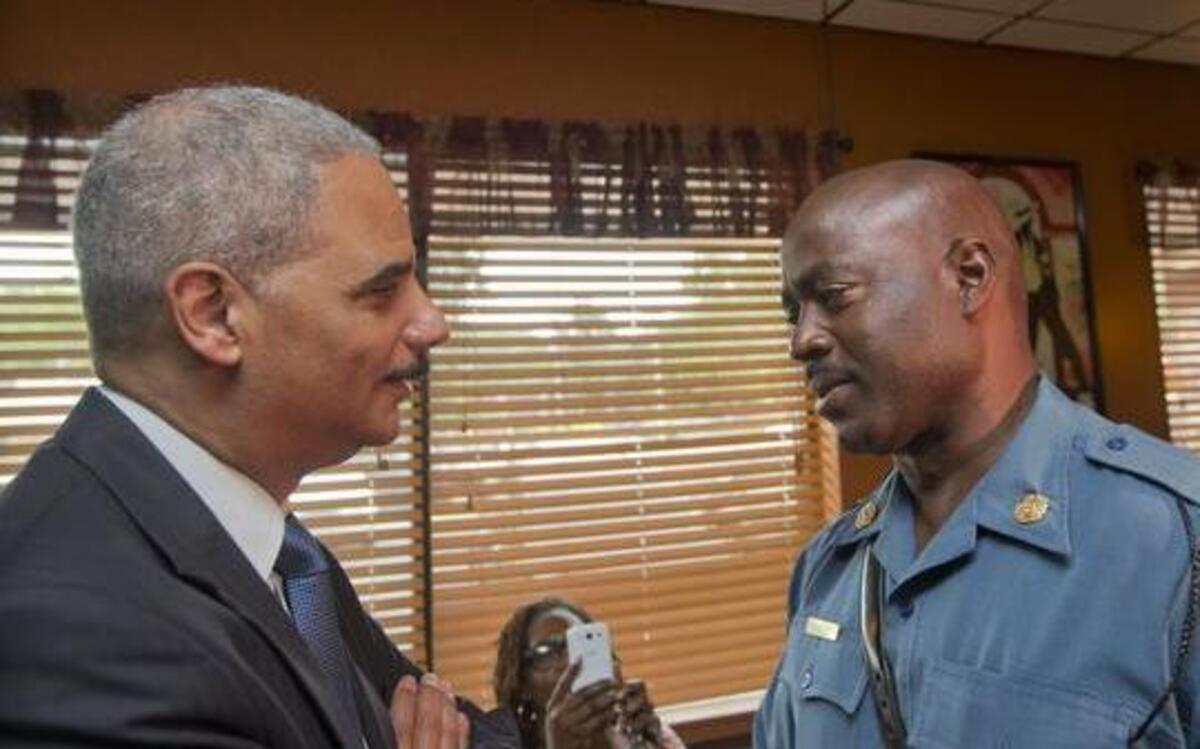 
U.S. Attorney General Eric Holder speaks with Capt. Ron Johnson of the Missouri State Highway Patrol 
