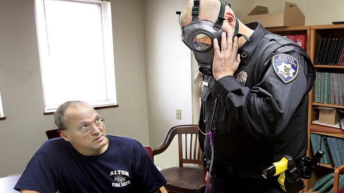 
Alton, Ill., Fire Department engineer Bob Eichen, left, uses a machine to run a series of five tests on the gas mask of Alton Police officer Michael Beaber

