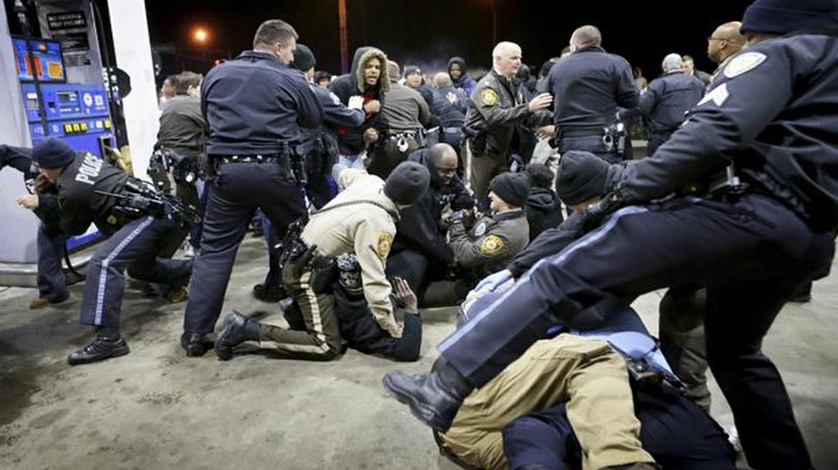 
Police try to control a crowd Wednesday at a gas station following a shooting Tuesday in Berkeley, Mo. 
