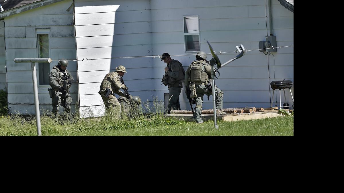 
Completing their search of a property thought to be the location of a suspect in the slaying of Sandra Sutton and Zachary Wade Sutton, Missouri Highway Patrol tactical officers appear to search the cellar of a home on Friday in Sedalia, Missouri. 
