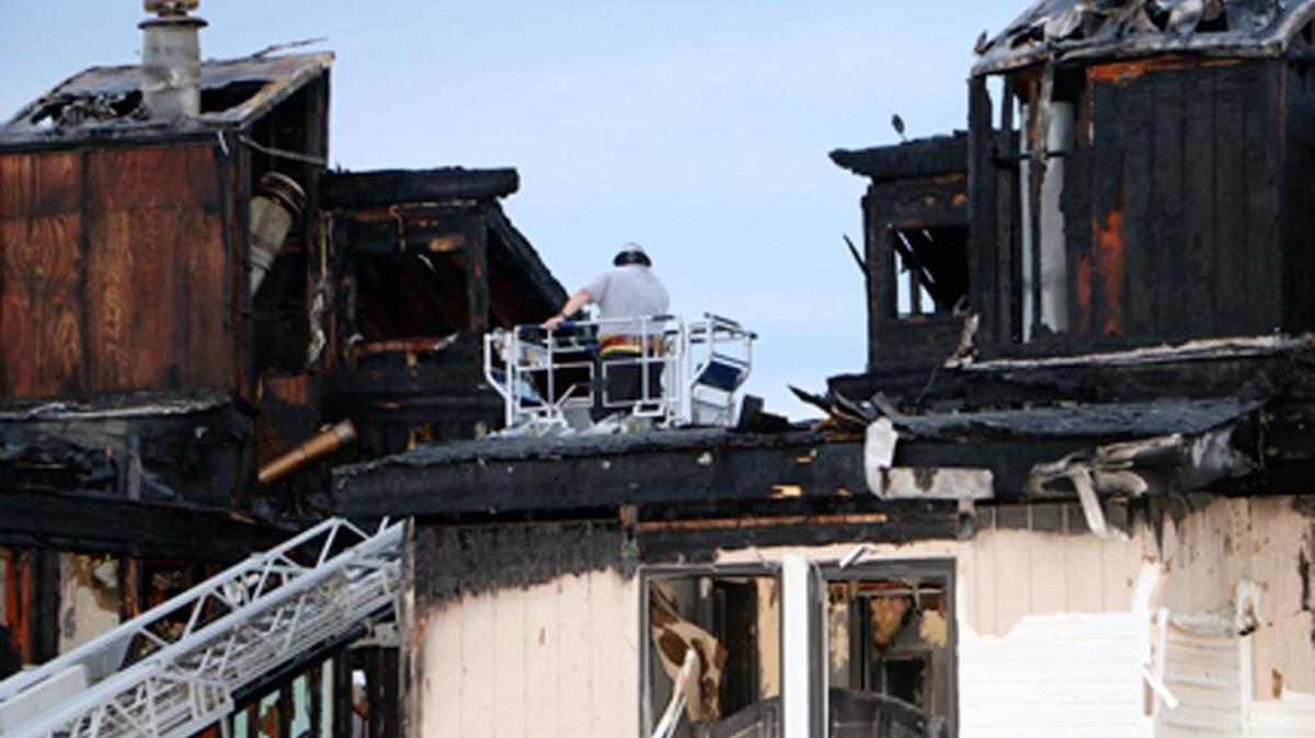 
In this photo provided by Dan Field, a fire investigator surveys the aftermath of an overnight fire Wednesday, Aug. 5, 2015 in Osage Beach, Mo.
