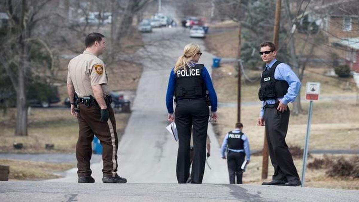 
Law enforcement officials canvassed the neighborhoods of Ferguson, Mo., on Thursday after two police officers were shot as a crowd gathered outside the Police Department. The injured officers were released from the hospital Thursday morning. 
