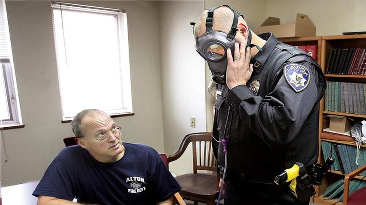 
Alton, Ill., Fire Department engineer Bob Eichen (left) used a machine to run a series of five tests on the gas mask of Alton Police Officer Michael Beaber on Monday at the Don Twichell Memorial Fire Station in Alton. The department has been preparing for any possible civil unrest or the need to assist other departments in advance of the verdict by the grand jury in the Ferguson, Mo., police shooting death of Michael Brown. 
