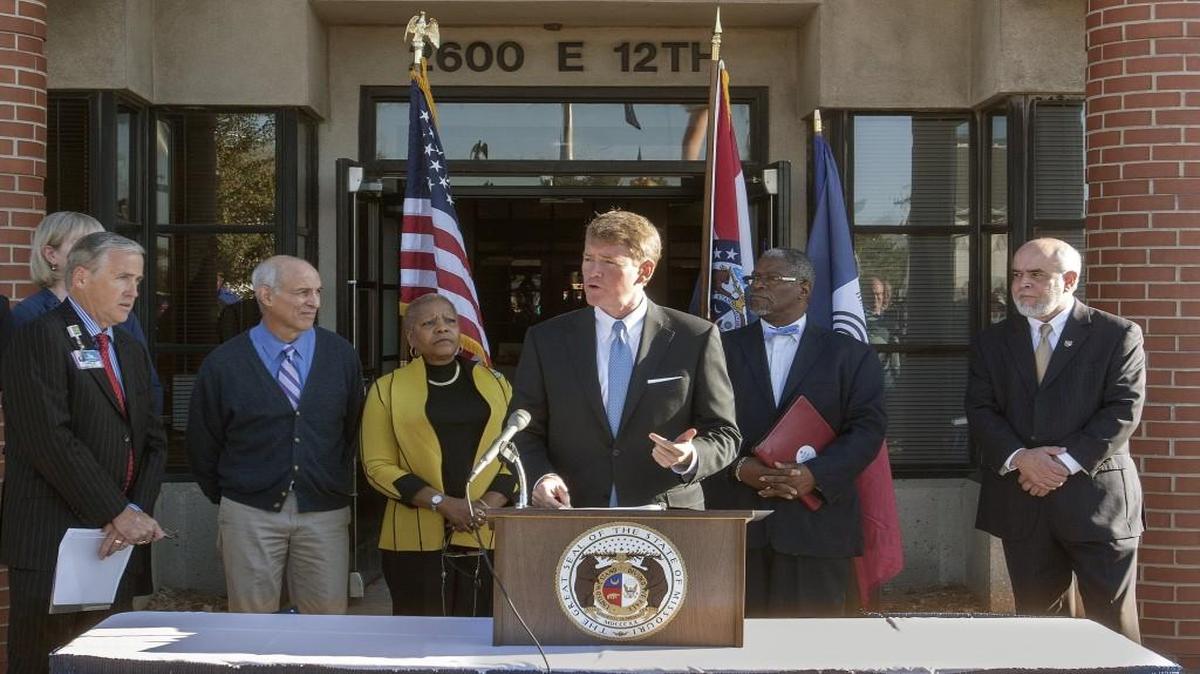 
Attorney General Chris Koster (center), along with state, county, city and foundation officials, announced an agreement with Ascension Health for $20 million in financial support for a planned mental health assessment and triage center at 2600 E. 12th St. 
