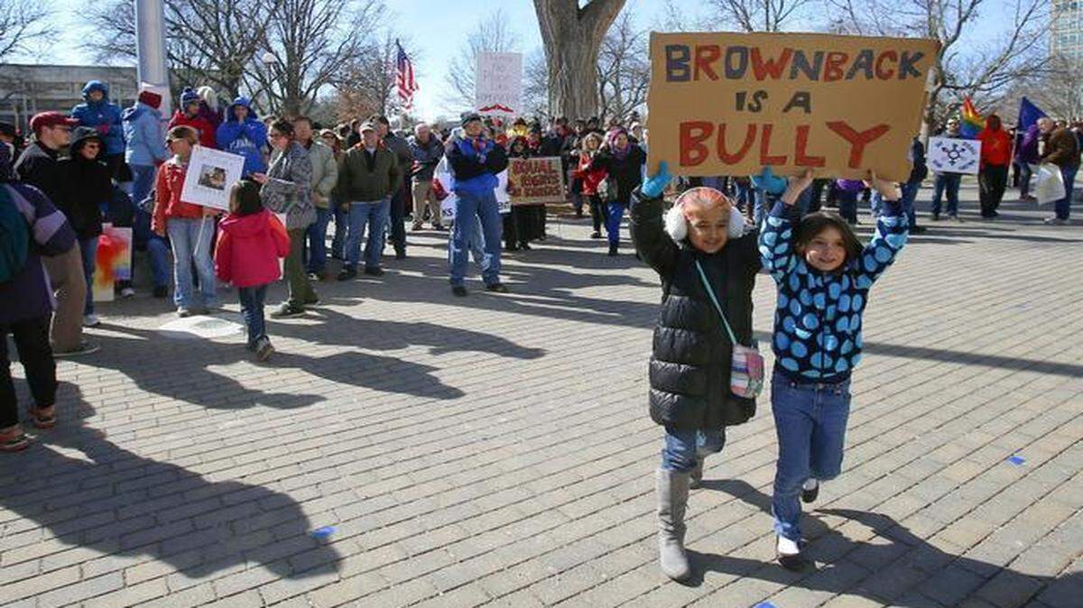 
Sylvia Porubsky (right), 7, and Marie Sewell, 8, held a sign as they joined hundreds of people at the Kansas statehouse in Topeka protesting against the governor’s actions against the LGBT community.
