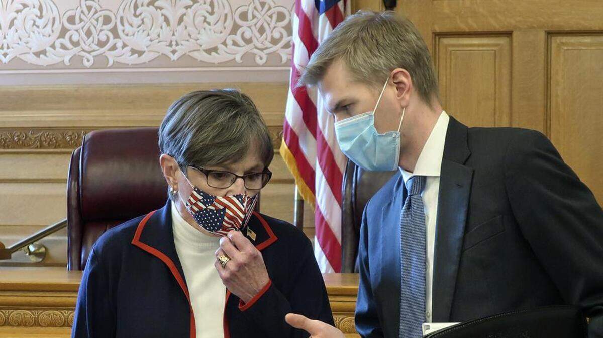 Kansas Gov. Laura Kelly, left, confers with Clay Britton, her chief attorney, before a July 2020 meeting with legislative leaders about an executive order she issued to require people to wear masks in public, (AP Photo/John Hanna)