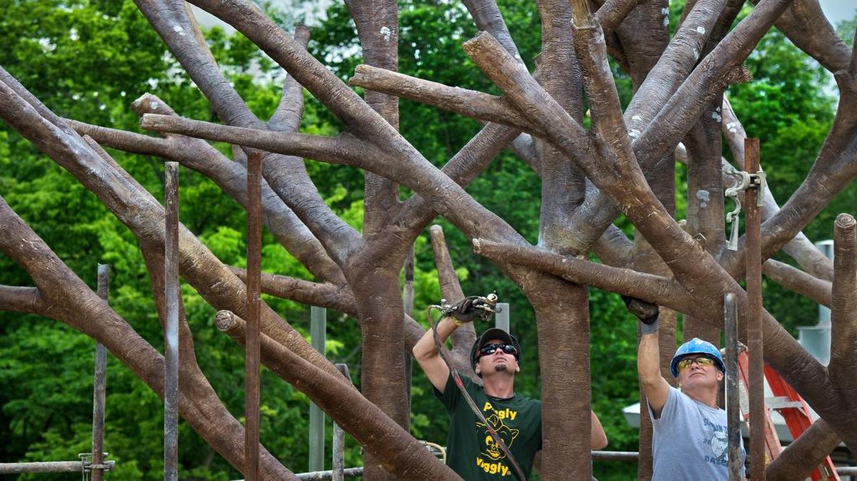
Rich Hopkins (left) and Joe Malia sprayed color onto the treelike centerpiece of the new orangutan exhibit at the Kansas City Zoo.
