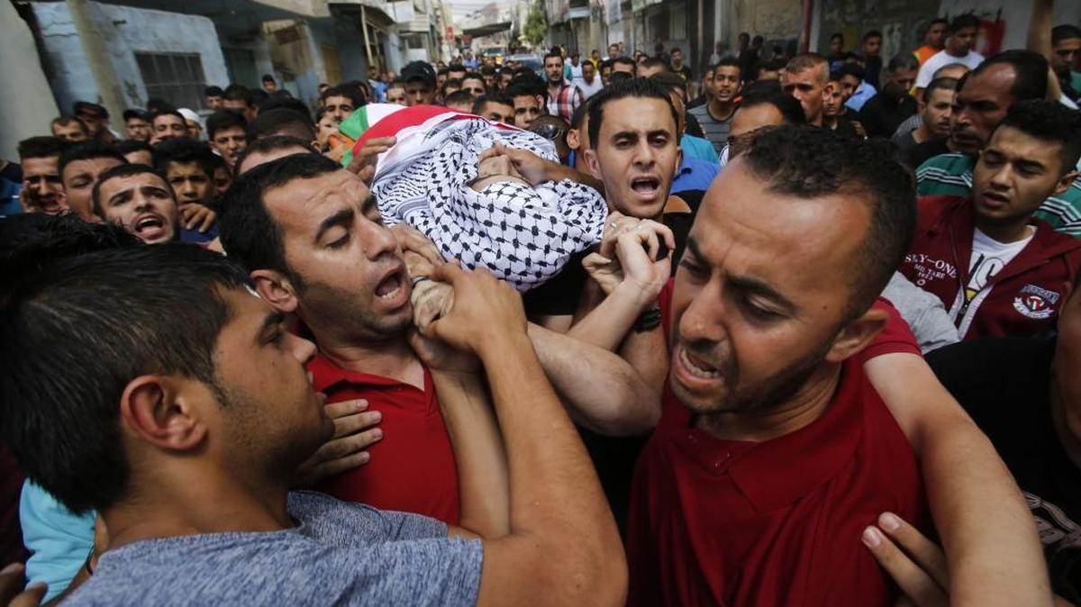 Palestinians carried the body of a 17-year-old boy killed during clashes between Israeli troops and Palestinians.