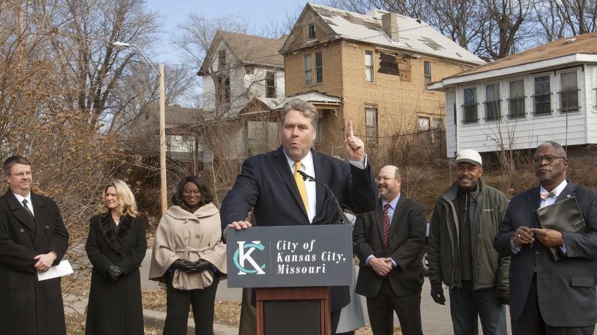 City Manager Troy Schulte (at podium) and Mayor Sly James (far right) made tearing down Kansas City’s dangerous building their top priority in the 2016-17 budget.