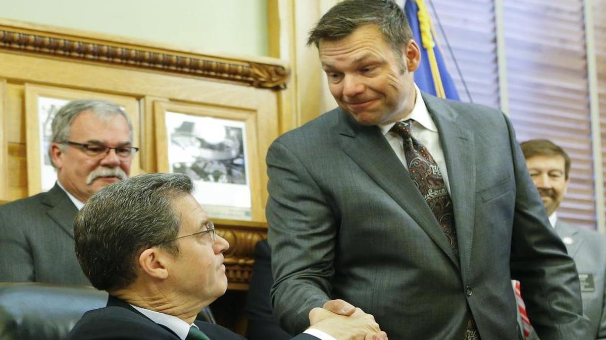 Kansas Secretary of State Kris Kobach, right, shook hands with Gov. Sam Brownback on Monday, June 8, 2015, after the signing of Senate Bill 34, a bill that grants persecuting power to the Secretary of State for cases of voter fraud.