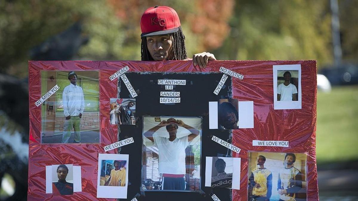 Durron Bailey held a poster memorializing his cousin, De’Anthoni Lee Sanders, 20, who was murdered Oct. 14, 2016, in Kansas City.