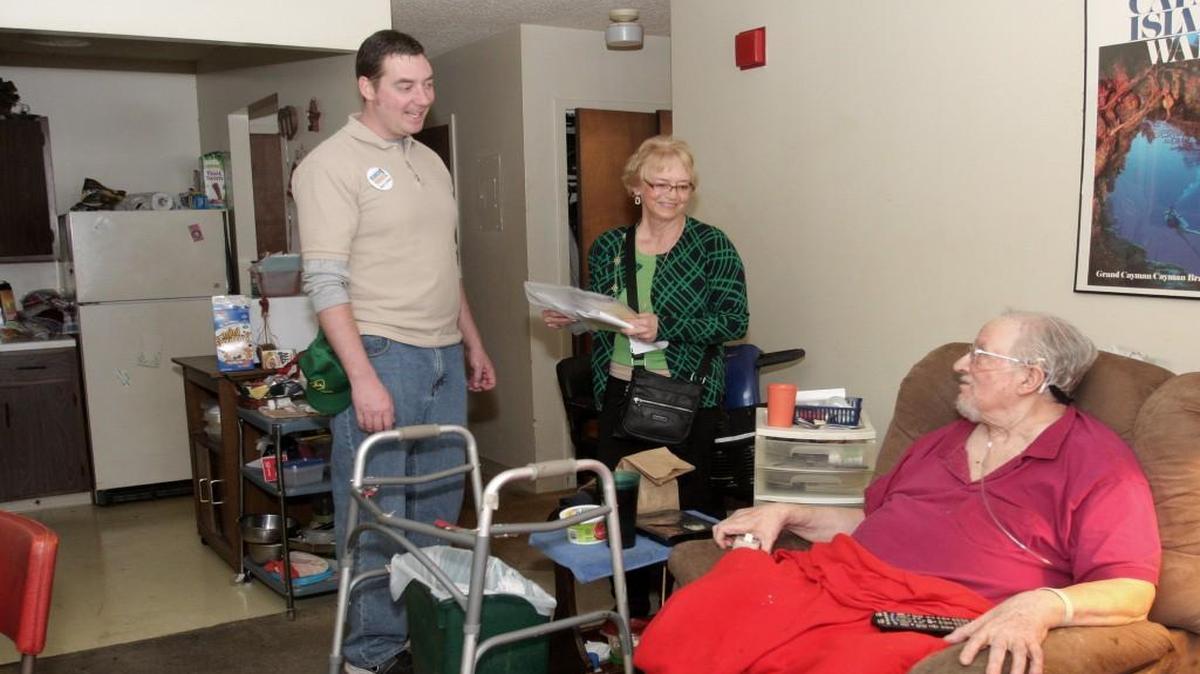 Johnson County Commissioner Jason Osterhaus and volunteer Suzanne Bessler in 2014 delivered Meals on Wheels to Alan DeLuca, a resident of Santa Fe Towers. The meals are provided by the Johnson County Area Agency on Aging.