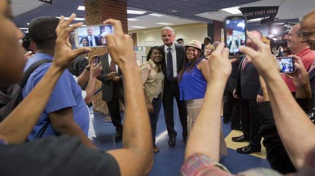
Ubiquitous cameras: Attorney General Eric Holder posed for photographs following his meeting Wednesday with students at St. Louis Community College Florissant Valley in Ferguson, Mo.
