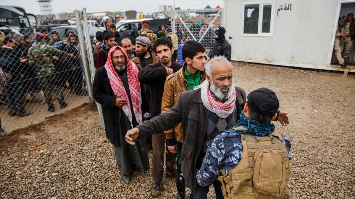 Incoming civilians to Iraq's Hammam Al-Alil camp in are checked for weapons, rounded up and checked for their identifications as part of Community Policing’s effort to screen incoming civilians in case ISIS members are hiding among them, on March 23, 2017, as they flee fighting in Mosul.
