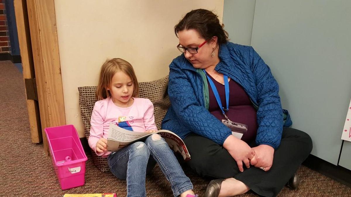 At Boone Elementary School, Trish Warford, a geographic information specialist with Burns & McDonnell, reads with 7-year-old Annie.