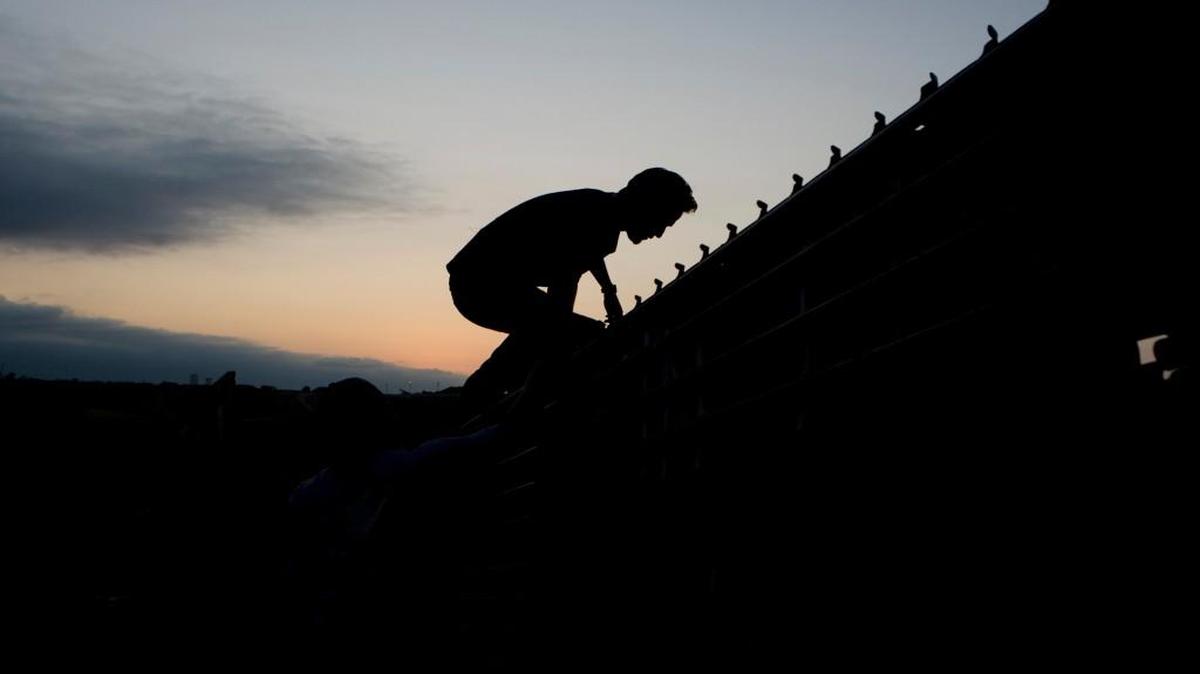 
A man climbs the border wall to cross into the United States from Tijuana, Mexico, showing that such barriers don’t always work to keep people out. 
