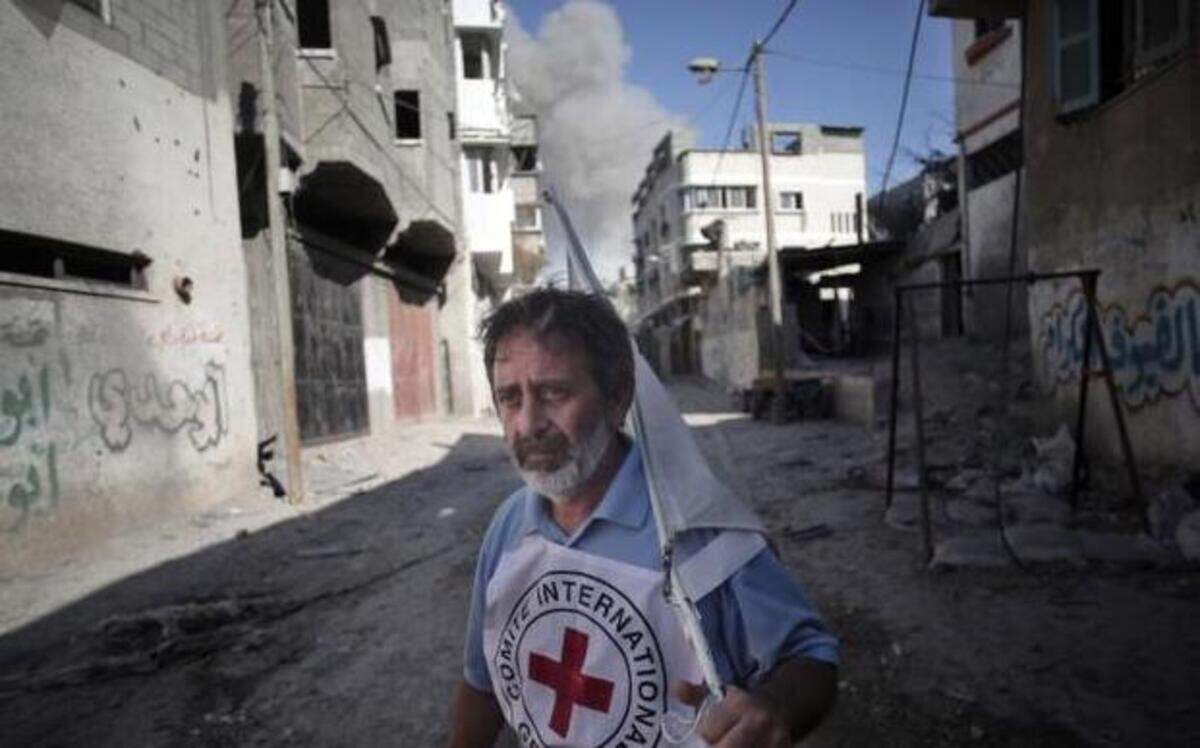 
An International Red Cross employee runs for cover Wednesday after an Israeli strike during a two-hour temporary ceasefire in Gaza City’s Shijaiyah neighborhood.
