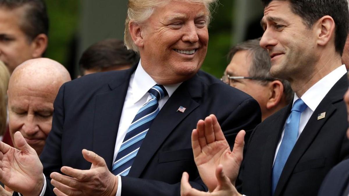 President Donald Trump smiles at House Speaker Paul Ryan in the Rose Garden after the House passed its health care bill.